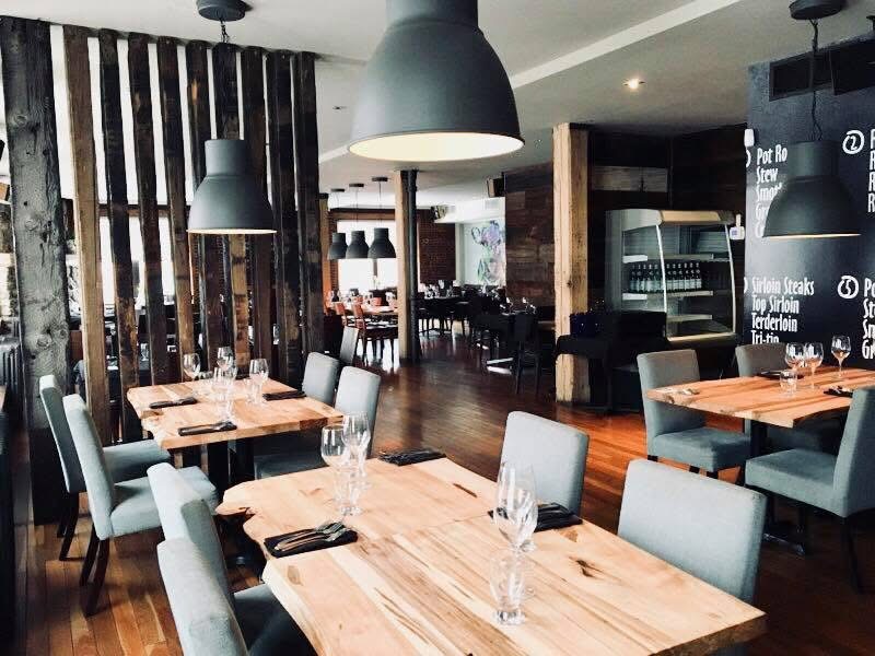 Salle du Restaurant La Suite — tables en bois, brique et luminaires