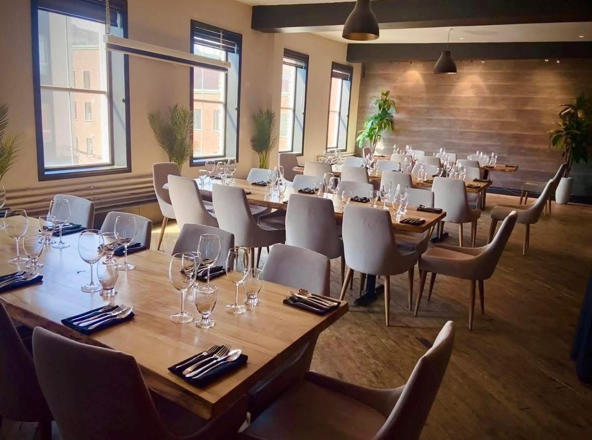 Salle de réception — grandes tables dressées, lumière naturelle